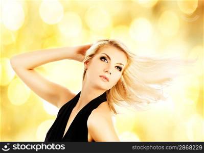 Beautiful blond woman over abstract golden background