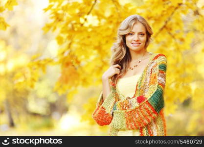 Beautiful blond woman posing in autumn park