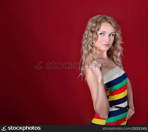 Beautiful blond woman showing thumb up on red background