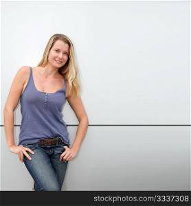 Beautiful blond woman standing on grey background