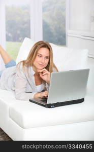 Beautiful blond woman surfing on internet at home