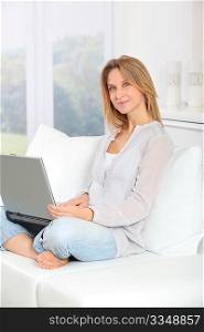 Beautiful blond woman surfing on internet at home