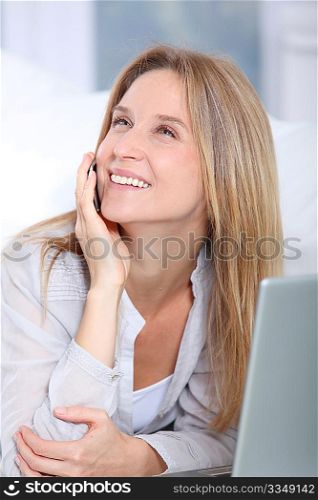 Beautiful blond woman surfing on internet at home