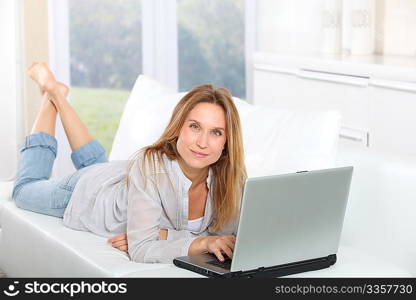 Beautiful blond woman surfing on internet at home