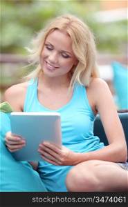 Beautiful blond woman websurfing with electronic tablet