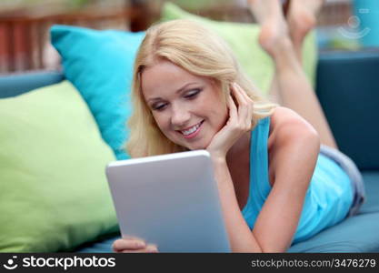 Beautiful blond woman websurfing with electronic tablet