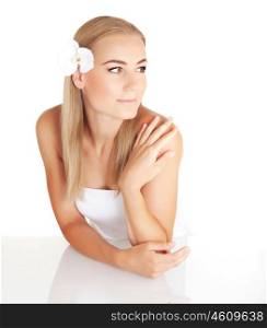 Beautiful blond woman with gentle orchid flower in hair isolated on white background, enjoying dayspa, luxury spa salon&#xA;