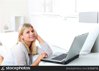 Beautiful blond woman with headphones in front of laptop