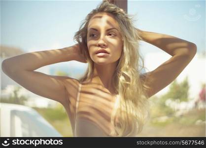 Beautiful blonde and the sun&rsquo;s rays through the palm leaf