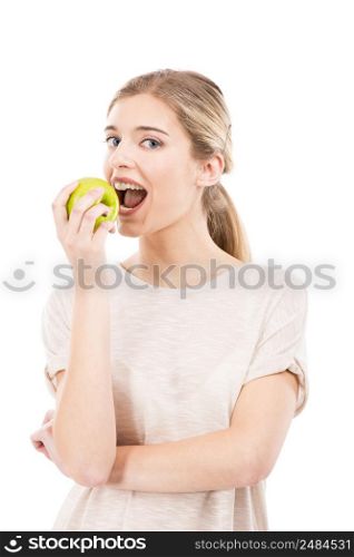 Beautiful blonde girl eating a green apple, over a white background
