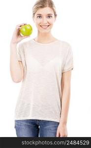 Beautiful blonde girl holding a green apple, over a white background