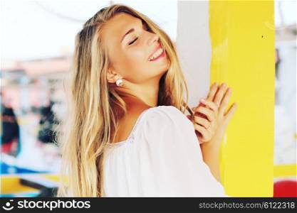 beautiful blonde girl posing with pink lips on the street the wind in your hair sun street fashion clothing