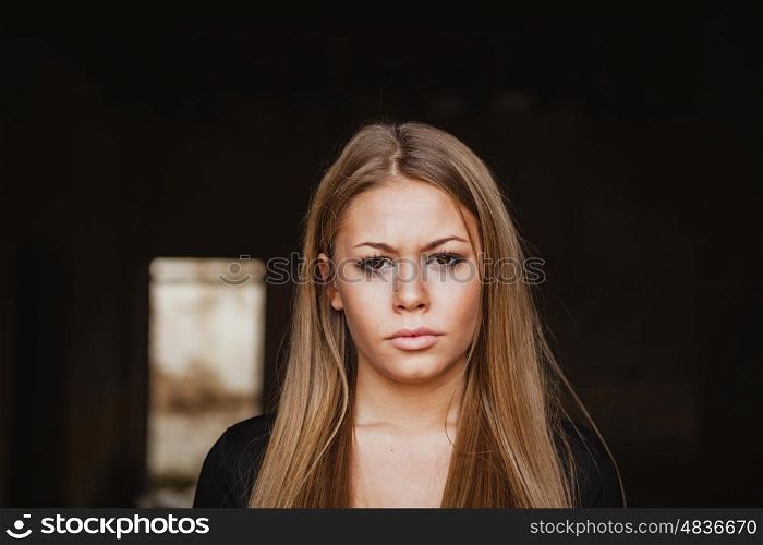 Beautiful blonde girl wih long hair and a sad expression