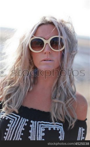 Beautiful blonde haired woman dressed in bohemian style at the beach