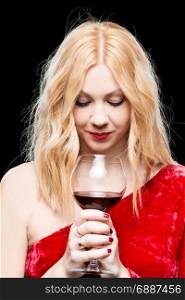Beautiful blonde in a red dress with a glass of wine on a black background
