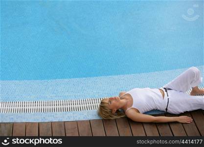 beautiful blonde resting on swimming pool edge