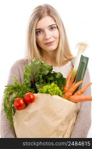Beautiful blonde woman carrying a bag full of vegetables, isolated over white background