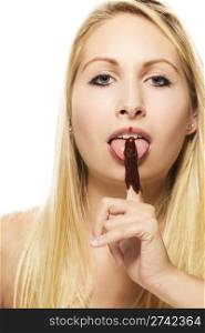 beautiful blonde woman licking on her chocolate covered finger. beautiful blonde woman licking on her chocolate covered finger on white background