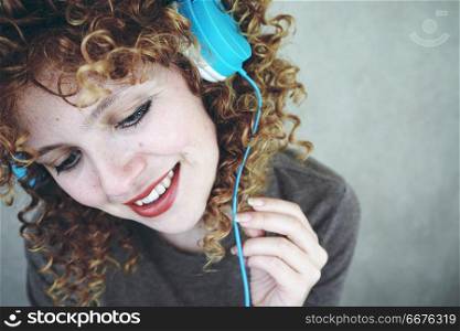 Beautiful blonde woman listening to music with her headphones