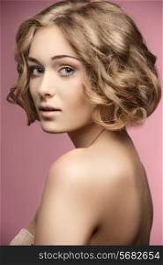 beautiful blonde woman posing with curly bob hair-cut and natural make-up. Naked shoulders, perfect skin