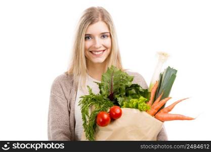 Beautiful blonde woman smiling and carrying a bag full of vegetables, isolated over white background