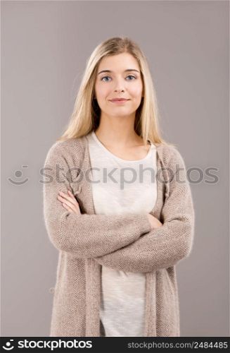 Beautiful blonde woman smiling and standing with hands folded