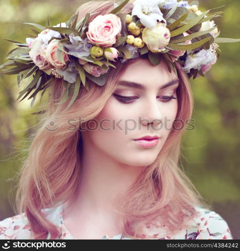 Beautiful blonde woman with flower wreath on her head. Beauty girl with flowers hairstyle. Girl in a summer forest. Fashion photo