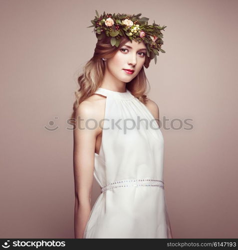 Beautiful blonde woman with flower wreath on her head. Beauty girl with flowers hairstyle. Perfect makeup. Beauty fashion. Spring woman