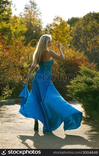 Beautiful blondy young woman wearing elegant blue dress