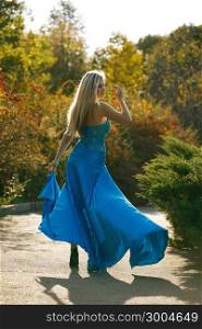 Beautiful blondy young woman wearing elegant blue dress