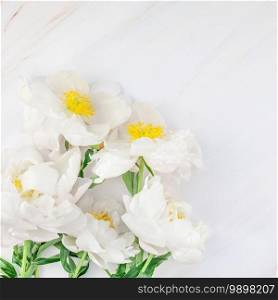 Beautiful blooming white peony flowers on marble background with copy space in minimal style, square template for postcard, text or your design. Wedding invitation and celebration greeting concept