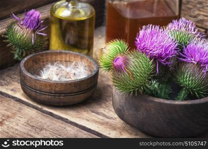 Beautiful blossoming buds thistle. Wild medicinal plant thistle on wooden background