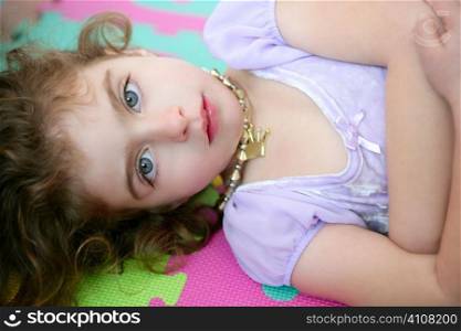 Beautiful blue eyes little girl liying on the floor