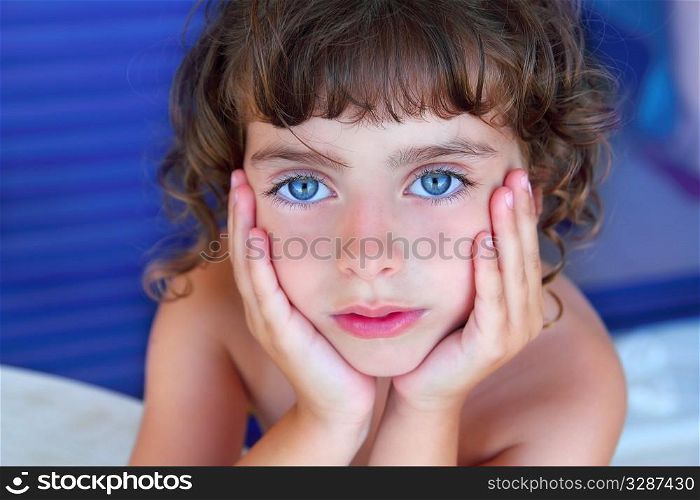 Beautiful blue eyes serene little girl portrait hands on face