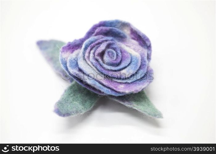 Beautiful blue rose flower milled wool on a white background.. Beautiful blue rose flower milled wool on a white background