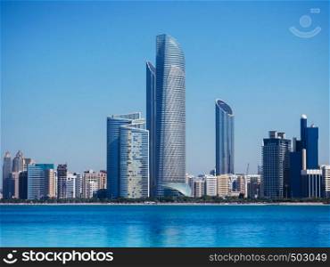 Beautiful blue sea with Abu Dhabi skyline and modern buildings cityscape view from marina island
