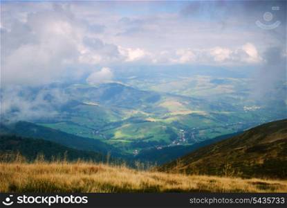 Beautiful blue sky and dry grass and view on the village in Carpathian mountains