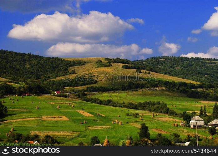 Beautiful blue sky and green grass with forest and meadows and gields are the villiage in Carpathian mountains