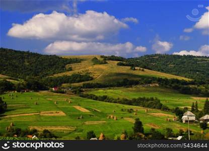 Beautiful blue sky and green grass with forest and meadows and gields are the villiage in Carpathian mountains