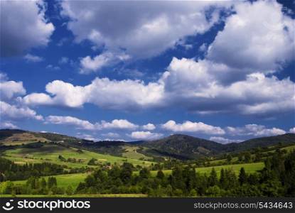 Beautiful blue sky and green grass with forest and meadows in Carpathian mountains