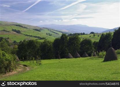Beautiful blue sky and green grass with road and fence in Carpathian mountains