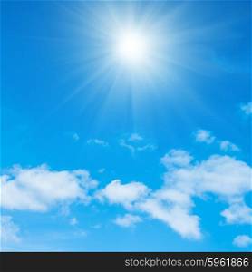 Beautiful blue sky, fluffy white clouds and shining sun with rays
