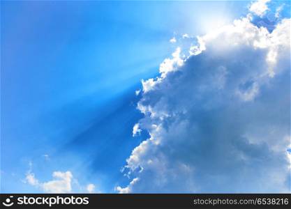 Beautiful blue sky with sunbeams and clouds. Sun rays. Beautiful blue sky