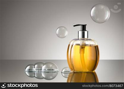Beautiful bottle of liquid hand soap with bubbles on a reflective surface