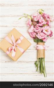 beautiful bouquet fresh pink eustoma flowers with present box wooden surface