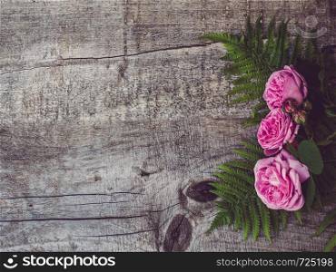 Beautiful bouquet of blooming peonies lying on unpainted, frayed boards. Place for your inscription. Top view, close-up. Greetings from loved ones, family, friends and colleagues. Beautiful, spring flowers lying on shabby boards