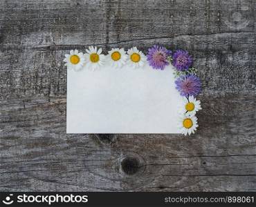 Beautiful bouquet of bright flowers, blank notepad page and unpainted boards. Place for your inscription. Top view, close-up. Congratulations to loved ones, family, relatives, friends and colleagues. Beautiful bouquet of bright flowers and notepad