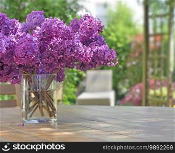 beautiful bouquet of purple lilac flowers on a wooden table in garden