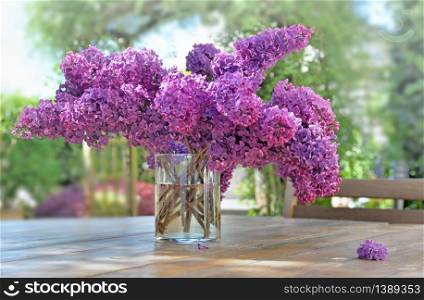 beautiful bouquet of purple lilac on a wooden table in garden