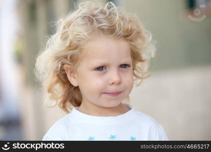 Beautiful boy three year old with long blond hair on a sunny day